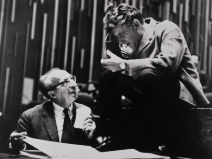 Two men in suits conversing.