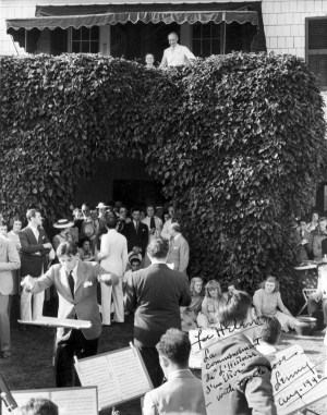 Bernstein conducts Stravinsky's L'histoire du Soldat at an informal Tanglewood tea party. Serge Koussevitzky - conductor and Bernstein mentor - and his wife Natalie look down from the balcony. The inscription to Helen Coates refers humorously to L'histoire d'un éléve - the tale of the student. 1940, courtesy of the Library of Congress Music Division