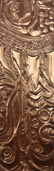Close up of a copper sheet with raised relief design